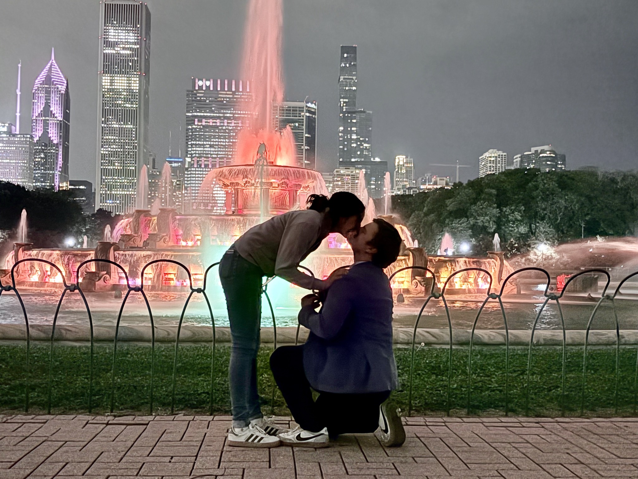 Paula and Felix kissing during their engagement at Buckingham Fountain in Chicago
